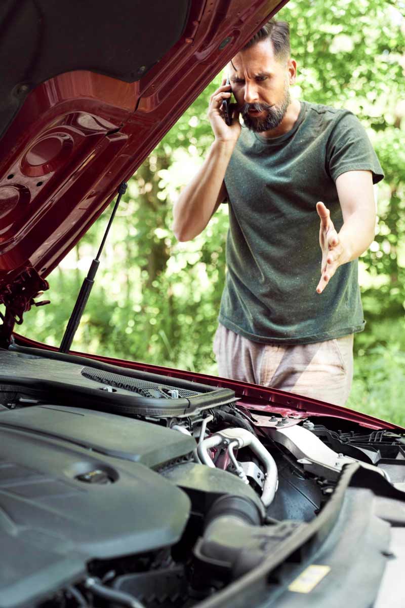 Junger Mann prüft Getriebeschaden bei Schrottauto Ankauf Pinneberg